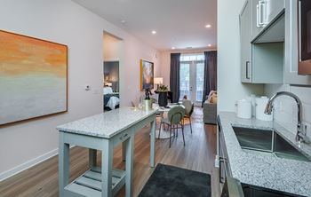A kitchen with a granite countertop and a painting on the wall.